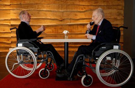 The world's oldest living twin brothers, Paulus and Pieter Langerock from Belgium, 102, drink a glass of red wine at the Ter Venne retirement home in Sint-Martens-Latem