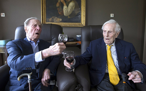 The world's oldest living twin brothers, Paulus and Pieter Langerock from Belgium, toast while sitting in their living room at the Ter Venne care home in Sint-Martens-Latem