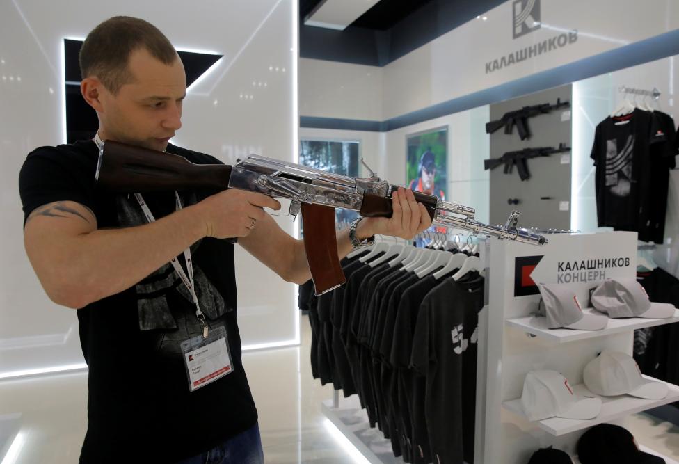 A salesperson demonstrates a model AK-47 assault rifle at the newly opened Gunmaker Kalashnikov souvenir store in Moscow's Sheremetyevo airport