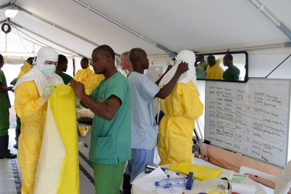 Medical workers put on Personal Protective Equipment (PPE) as they prepare before leaving for a high-risk area of the Elwa hospital runned by Medecins Sans Frontieres (Doctors without Borders), on September 7, 2014 in Monrovia. President Barack Obama said in an interview aired September 7 the US military would help in the fight against fast-spreading Ebola in Africa, but said it would be months before the epidemic slows. The death toll from the Ebola epidemic -- which is spreading across West Africa, with Liberia, Guinea, Sierra Leone the worst hit -- has topped 2,000, of nearly 4,000 people who have been infected, according to the World Health Organization. AFP PHOTO / DOMINIQUE FAGET (Photo credit should read DOMINIQUE FAGET/AFP/Getty Images)