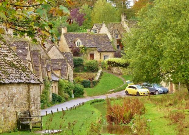 Paul Lemons' holiday photograph of the famous cottages of Arlington row featuring the yellow car which has blighted many tourists pictures. See SWNS story SWYELLOW; A bright yellow car is photo-bombing England's most picturesque view. Tourists' picture-postcard shot of the Cotswold's Arlington Row are being ruined by "ugly" car - which is appearing in photographs all over the world. The 14th century cottages, owned by the National Trust, are the most photographed cottages in Britain and attract swarms of visitors every year. The car's owner, Peter Maddox, 82, said there was nothing he could do about the banana yellow car.