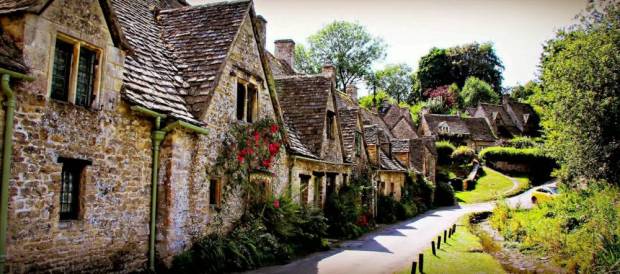 Sean Farr's holiday photograph of the famous cottages of Arlington row featuring the yellow car which has blighted many tourists pictures. See SWNS story SWYELLOW; A bright yellow car is photo-bombing England's most picturesque view. Tourists' picture-postcard shot of the Cotswold's Arlington Row are being ruined by "ugly" car - which is appearing in photographs all over the world. The 14th century cottages, owned by the National Trust, are the most photographed cottages in Britain and attract swarms of visitors every year. The car's owner, Peter Maddox, 82, said there was nothing he could do about the banana yellow car.