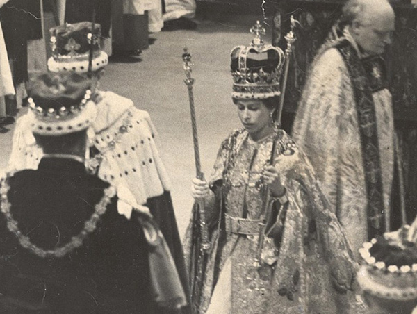 R565 LP3D CORONATION DAY WESTMINSTER ABBEY 2ND JUNE 1953 NOW CROWNED. The Queen stands holding the Sceptre and the Rod. She is wearing the Robe Royal of Cloth of Gold and the Pall Royal over the Golden Supertunica. The bishops and archbishops move forward for the symbolic lifting of the Queen into the Throne.